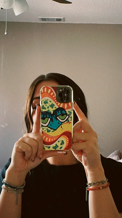 perri holding a hand painted phone case in front of her face