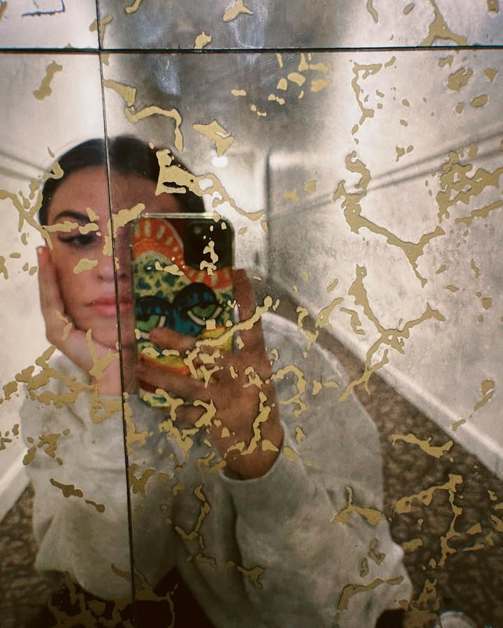 a photo of perri's reflection in a gold cracked mirror